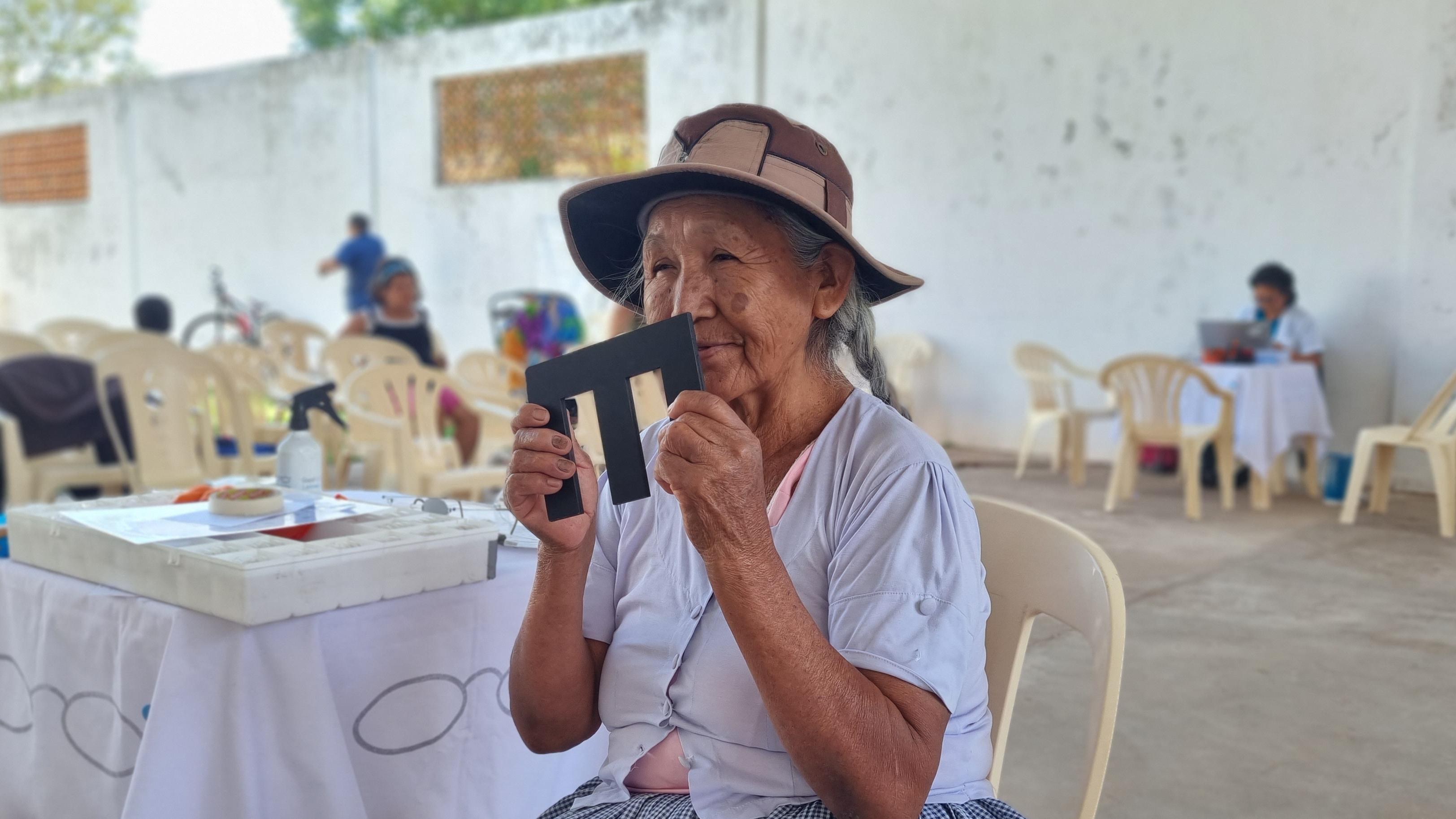 Frau in Bolivien hält Sehproben E