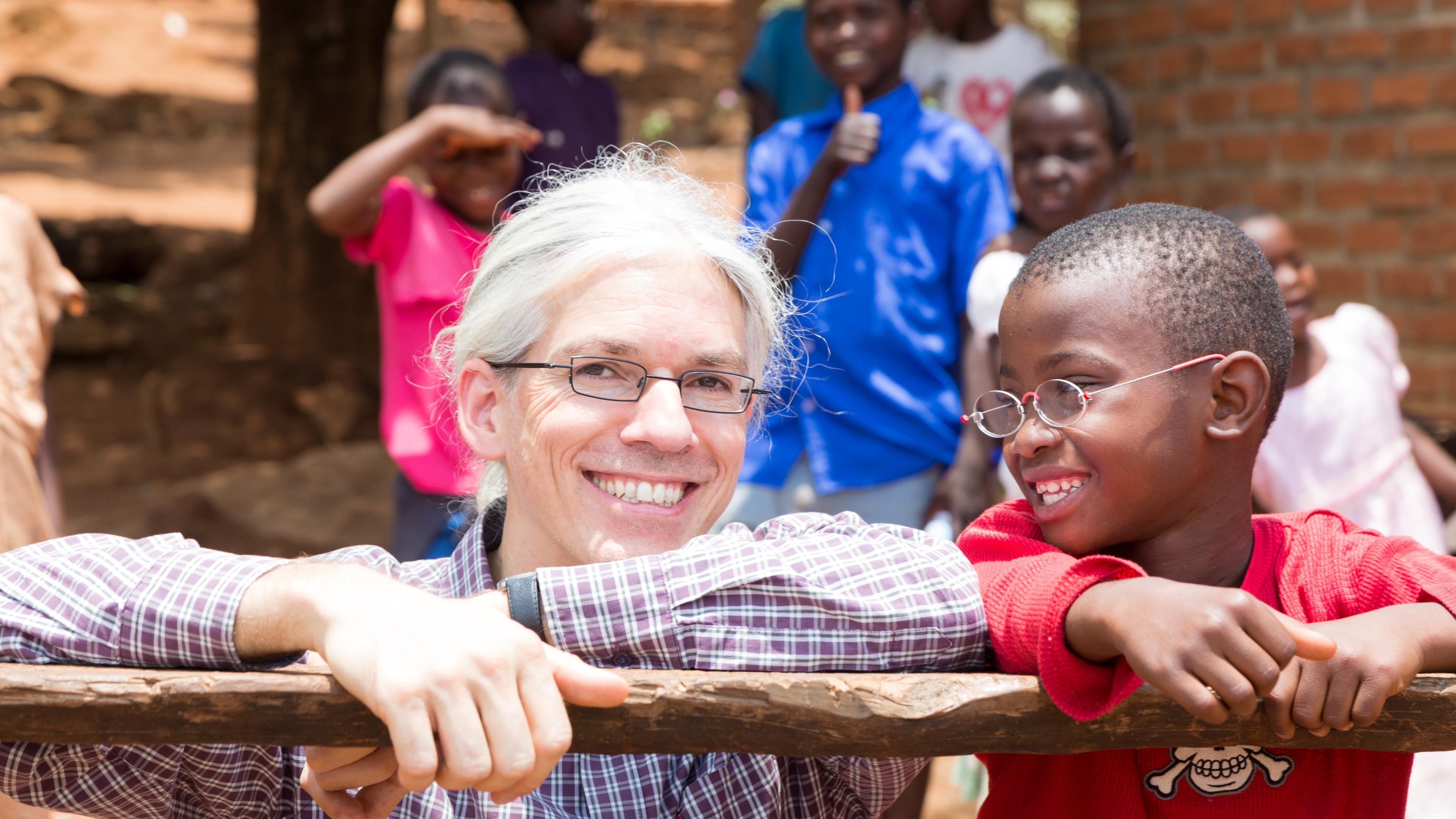 Martin Aufmuth mit einem Jungen, der EinDollarBrille trägt in Malawi