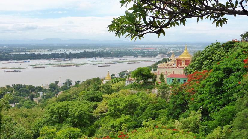 Panorama in Myanmar, grüne Wälder, Tempel mit goldenen Dächern, Fluss im Hintergrund