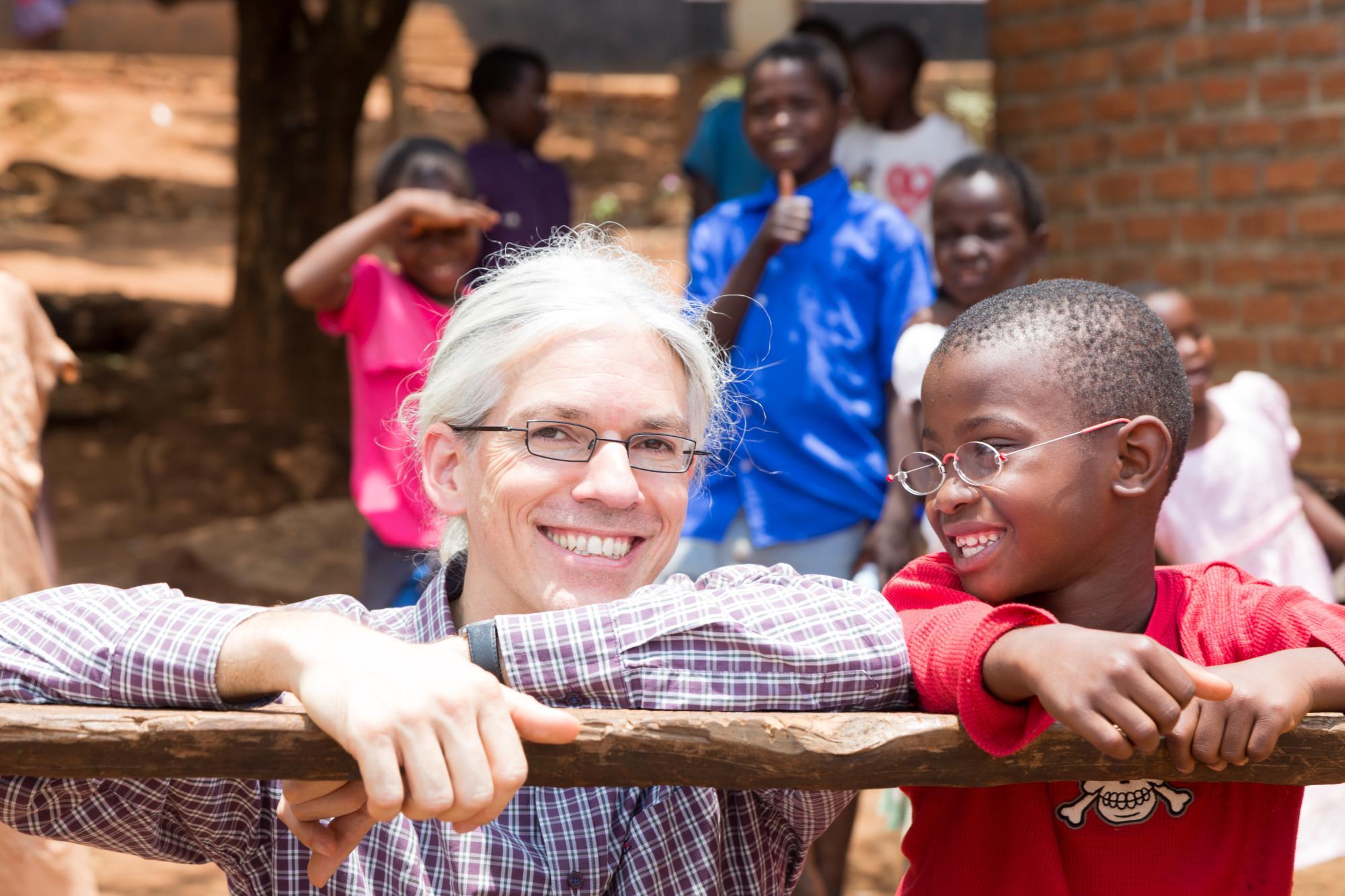 Martin Aufmuth mit einem Jungen, der EinDollarBrille trägt in Malawi