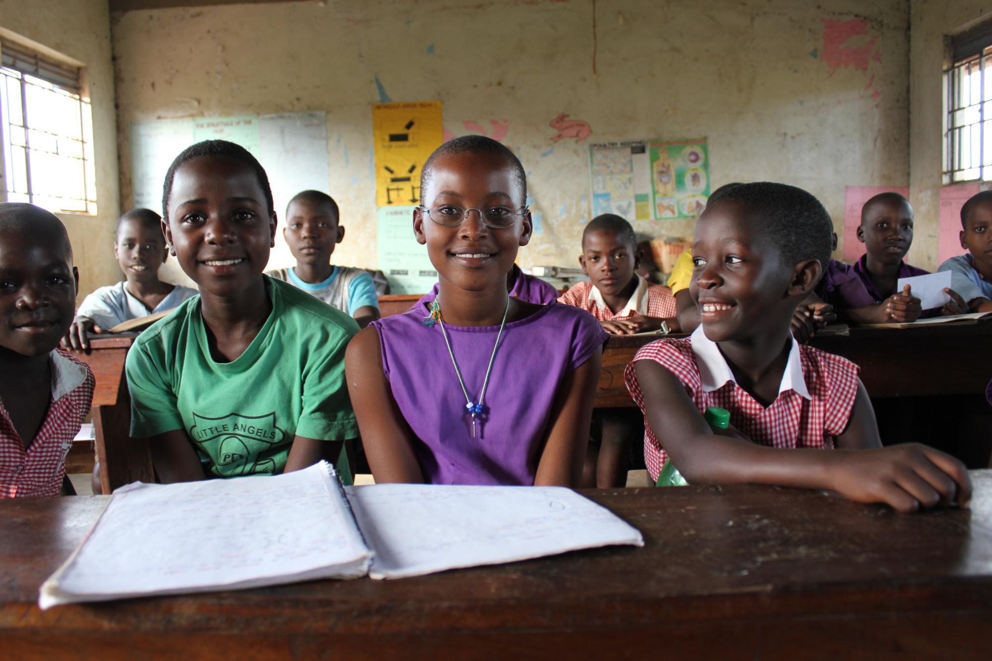 Schülerinnen aus Uganda im Klassenzimmer, eine trägt EinDollarBrille