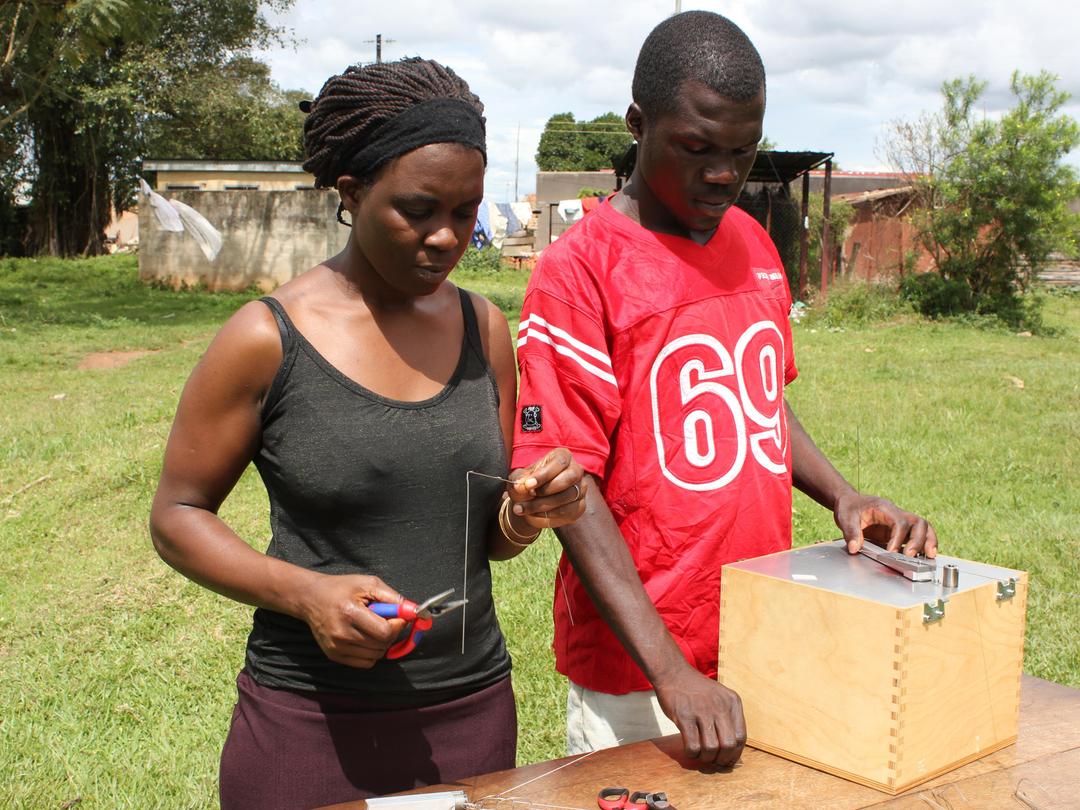 Mann und Frau an der Biegemaschine in Uganda