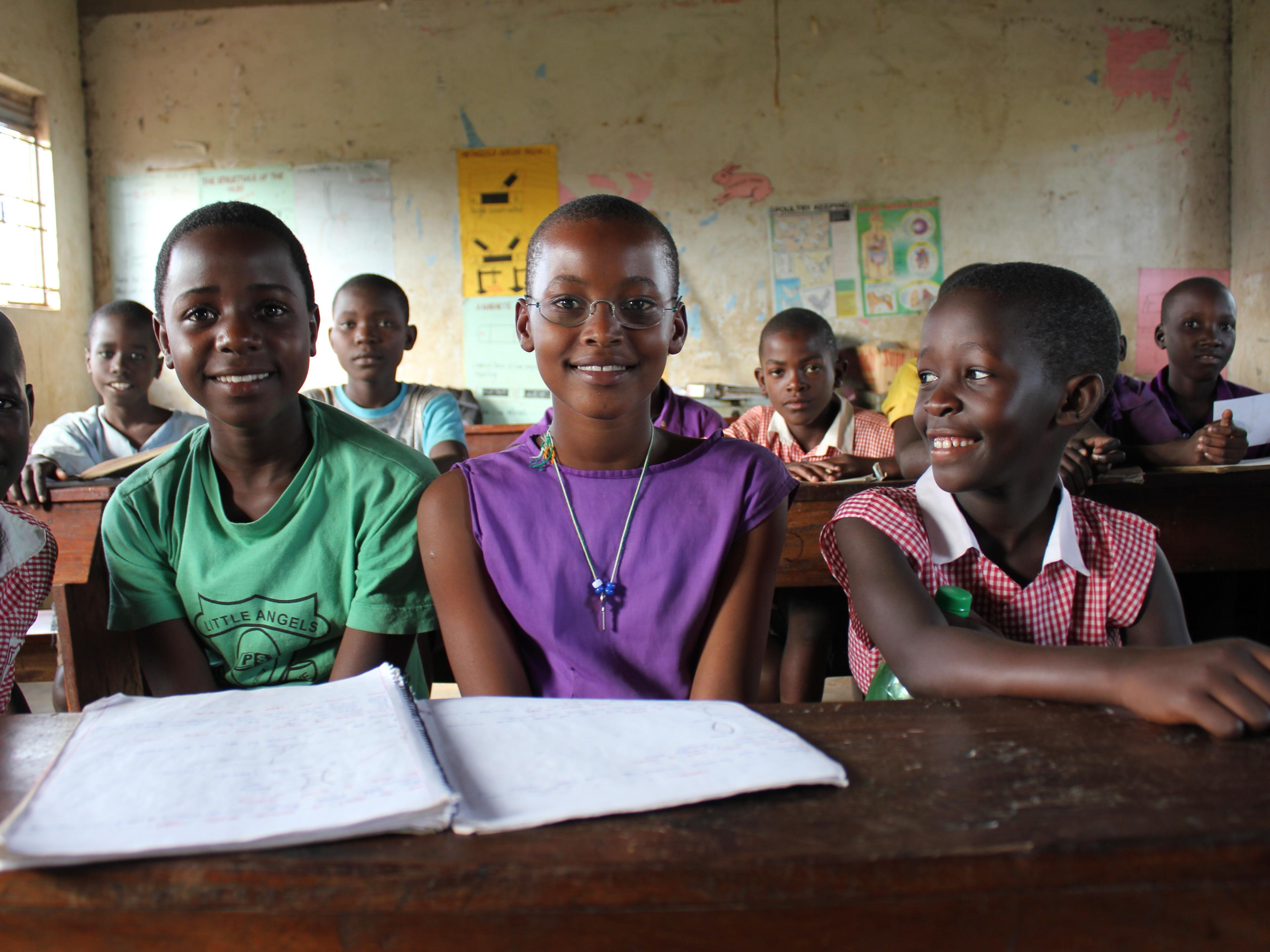 Schülerinnen aus Uganda im Klassenzimmer, eine trägt EinDollarBrille